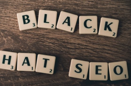 a scrabble tiles spelled the word black hat SEO on a wooden table which refers to the domain squatting on black hat practices