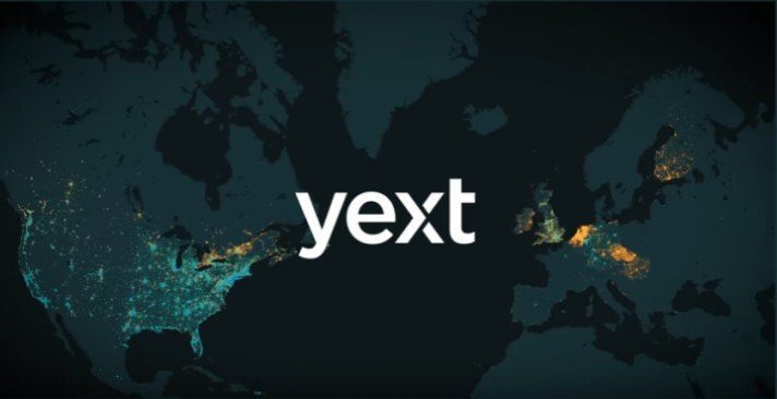 An image of the word yext in white color with a background of a world map in green
